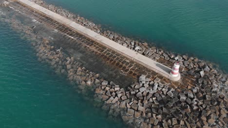 Maritime-Lighthouse-on-Rocky-Portugal-Coast-Pier---Aerial