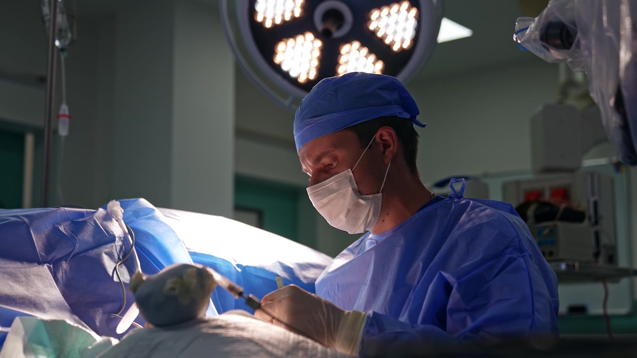 Il chirurgo usa strumenti metallici durante un'operazione alla mano. Ritratto di un medico professionista che esegue un intervento chirurgico.