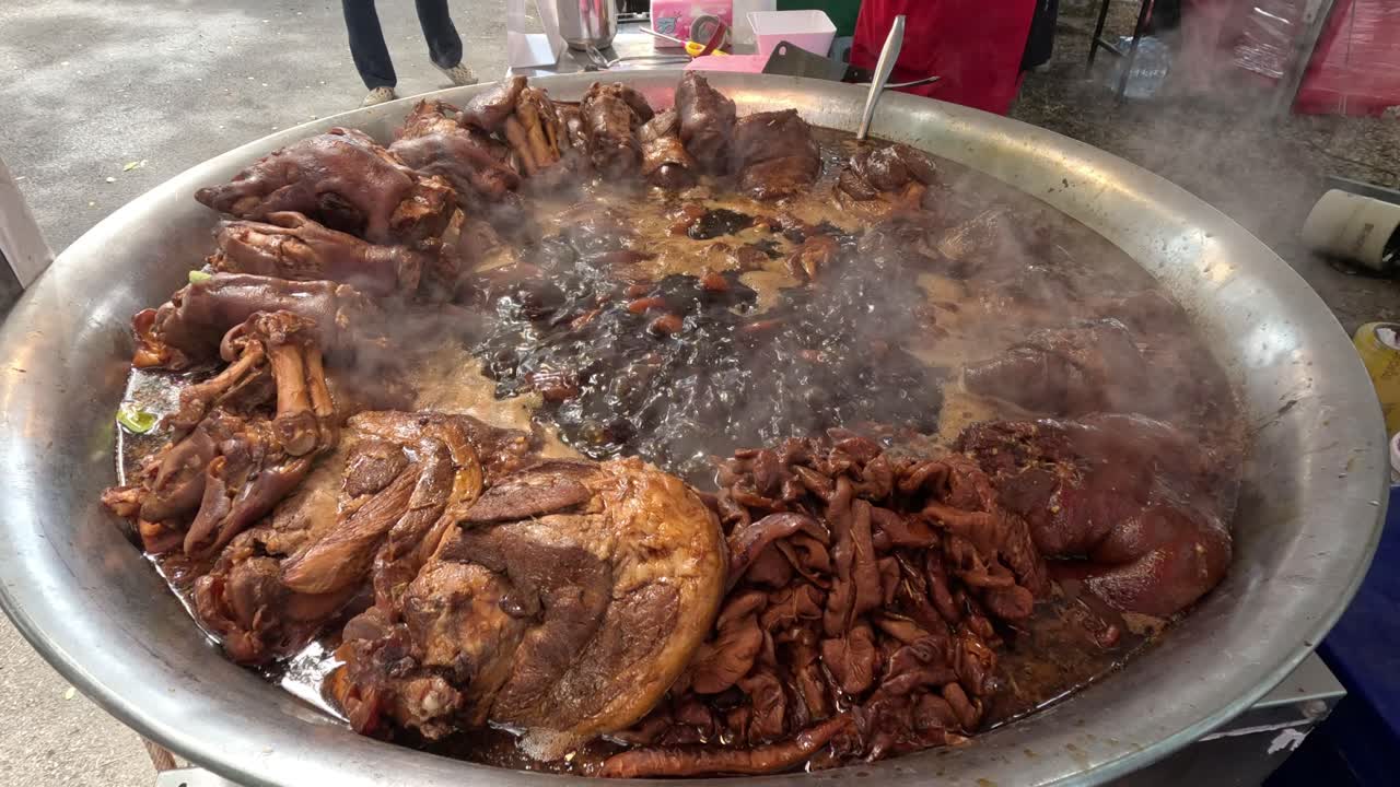 Grande pentola di stufato che cuoce all'aperto con vapore