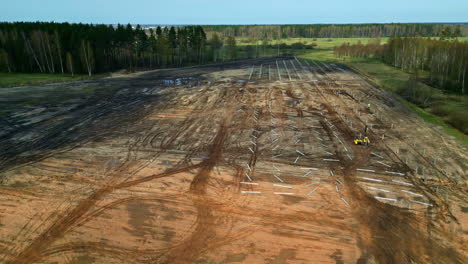 drone circling the construction site of a large solar panel park, spring day