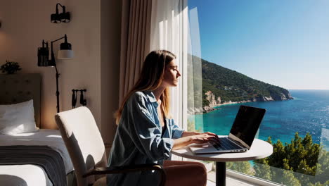 woman working on laptop with sea view