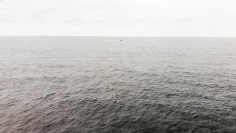 aerial shot of one lone motor boat speeding through the endless waves of the open ocean