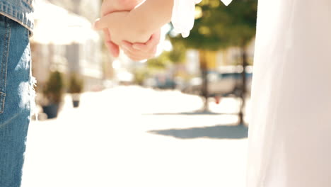 couple holding hands walking in the city