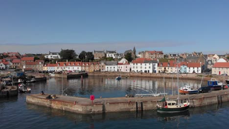 aerial pan up of st monance harbour and the village beyond