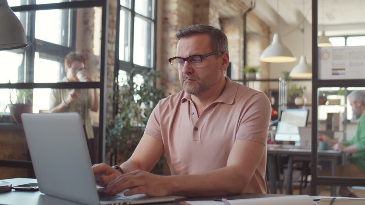 Man Working on Laptop in Modern Office