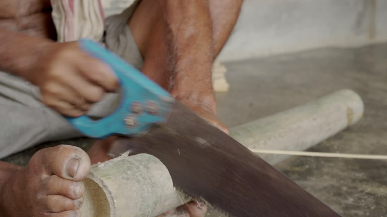 craftsman indian male cutting a bamboo stick making artisan product