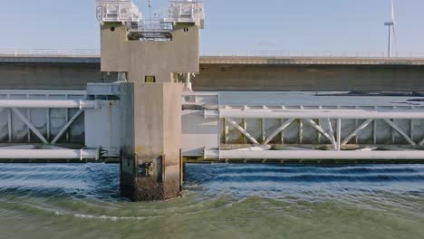 Aerial-shot-of-the-concrete-and-steel-front-of-the-Eastern-Scheldt-storm-surge-barrier-in-Zeeland,-the-Netherlands,-on-a-beautiful-sunny-day