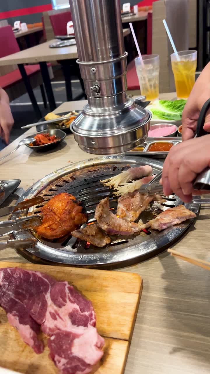 Diners enjoy grilling meat at a Korean BBQ restaurant in Bangkok ...