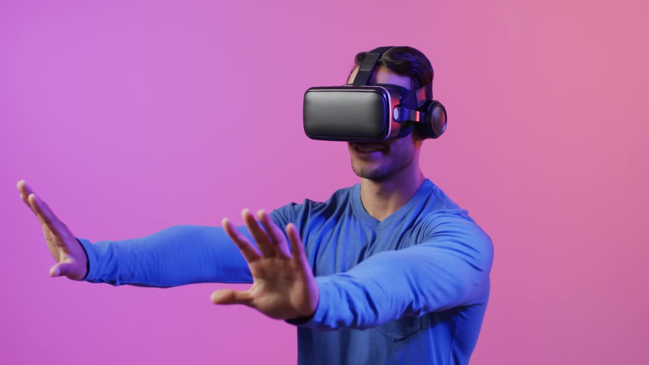 video di un uomo caucasico che usa le cuffie vr su sfondo rosa e viola