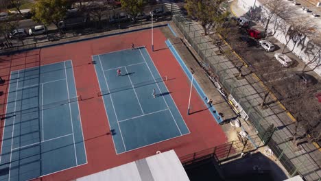 aerial birds eye shot of tennis double playing game on tennis court during sunlight,4k