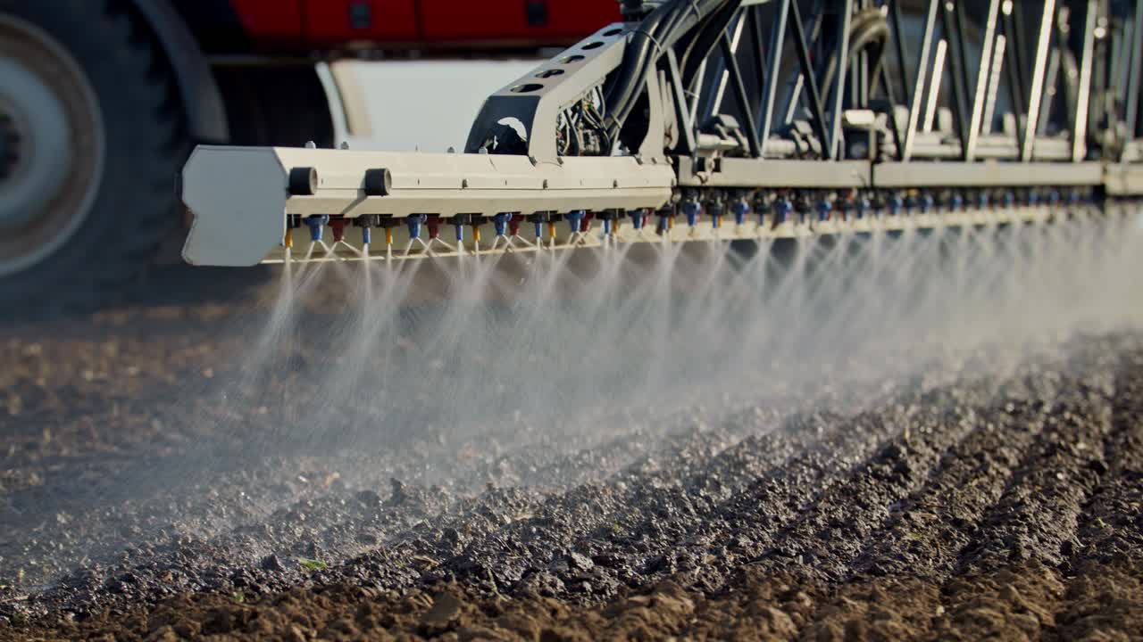 빨간 기계에서 농업 캠페인에 토양을 살포하는 농부의 클로즈업