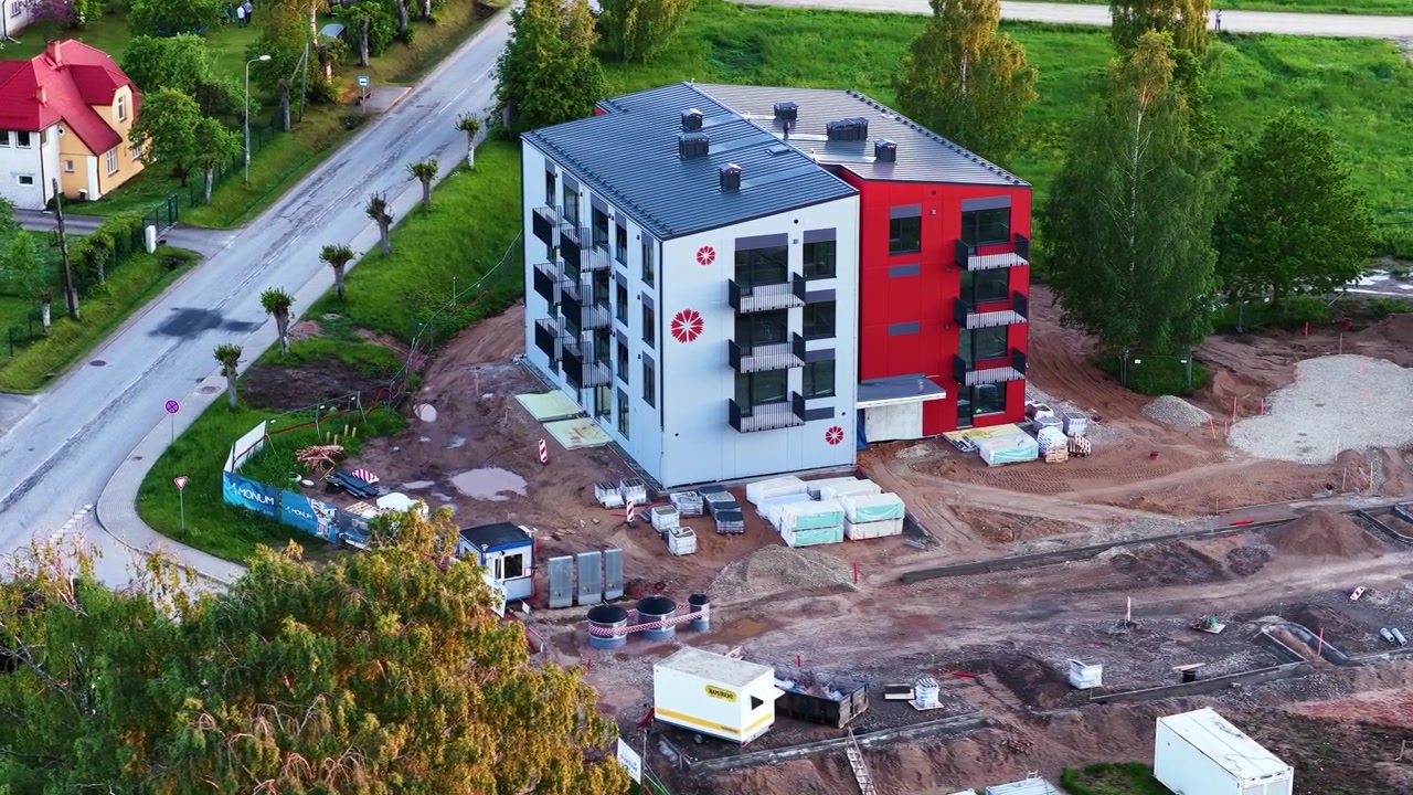 Ripresa aerea di un moderno condominio situato in mezzo a un cantiere edile trafficato