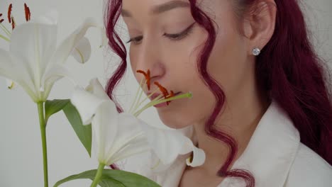 mujer perfecta con cabello rizado disfruta de la flor de lirio blanco, fondo blanco aislado