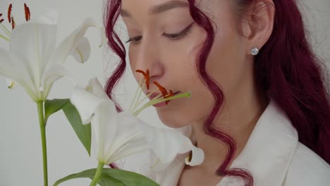 perfect woman with curly hair enjoys white lilly flower, isolated white background