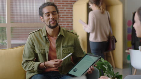 young mixed race businessman using tablet computer showing clients business ideas pointing at screen entrepreneurs brainstorming enjoying teamwork connection in modern office