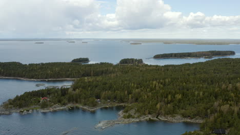 aerial tilt up drone shot over islands, towards the open sea, at the gulf of finland, on a sunny day, in the porvoo archipelago, in uusimaa