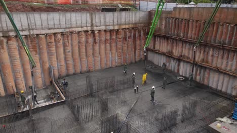 aerial view of construction workers laying cement using automatic pump, israel