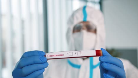 Close-Up-Shot-Of-Healthcare-Worker-Hands-In-Protective-Gloves-Holding-Coronavirus-Test,-Pcr-Testing,-Doctor-Or-Nurse-In-Protective-Uniform-Showing-Test-Sample-To-Camera,-Pandemic-Virus-Disease