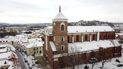 Edificio-De-La-Basílica-De-La-Catedral-De-Kaunas-Cubierto-De-Nieve,-Drones-Aéreos-Vuelan-Hacia-La-Vista