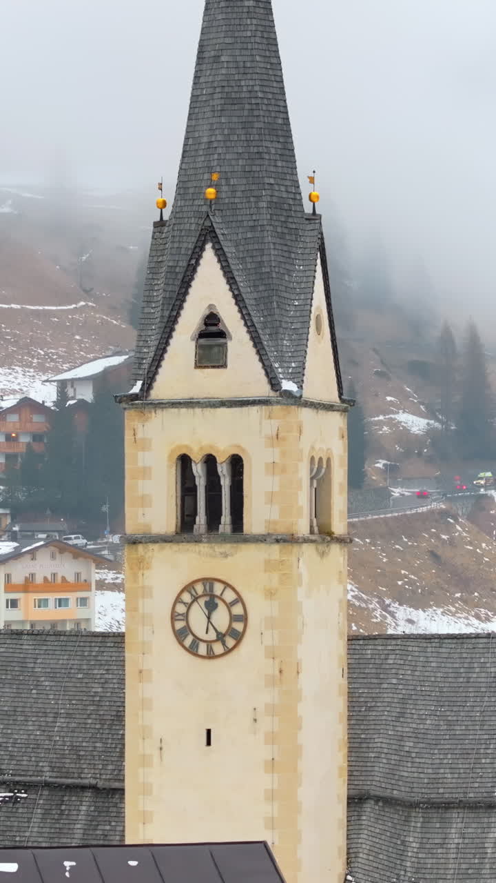 Aerial drone view of the Chiesa di Arabba in the Arabba village, in the Dolomites, Italy. Vertical