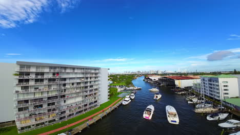 numerous boats and yachts are standing or sailing by the river. fpv drone flies over the city scenery turning 180 degrees.