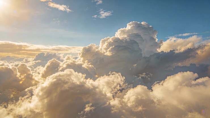 Sliding camera moving forward right over clouds at sunset, sun left, towering cloud casting shadows