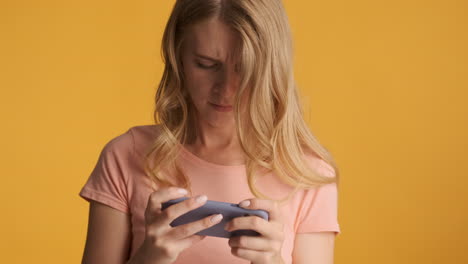 caucasian woman playing video games on smartphone.