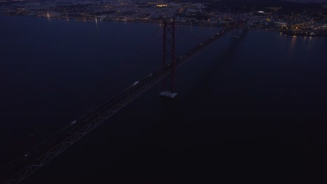 reveal shot of famous ponte 25 de abril bridge at lisbon with blue hour, aerial