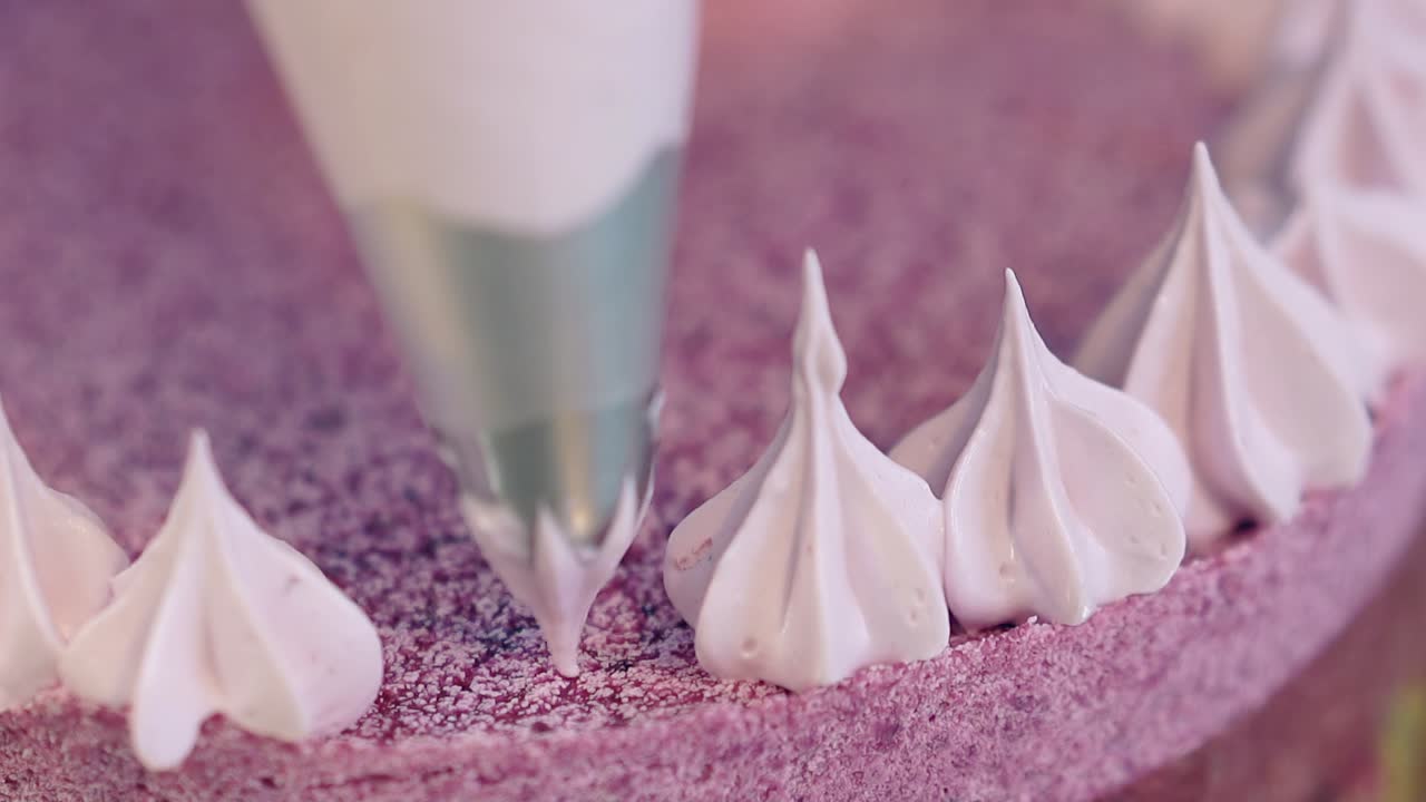 el confitero forma un contorno de pastel de galletas con flores de crema