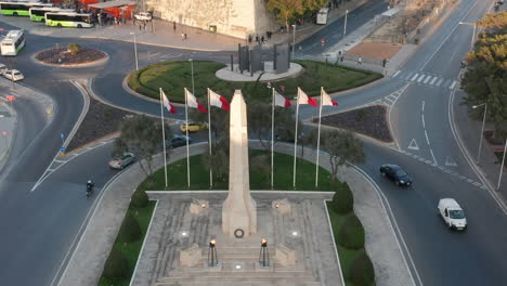 aerial drone shot of the national flag and the war memorial in the valletta, the capital city of malta