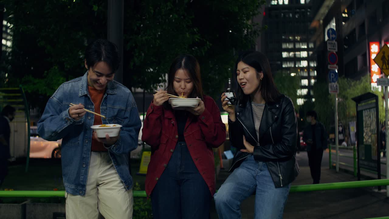 Friends Enjoying Nighttime Street Food in Japan