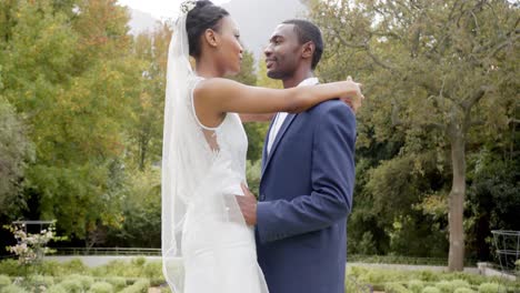 Fröhliche-Afroamerikanische-Braut-Und-Bräutigam-Tanzen-Bei-Ihrer-Hochzeit-Im-Garten,-Zeitlupe