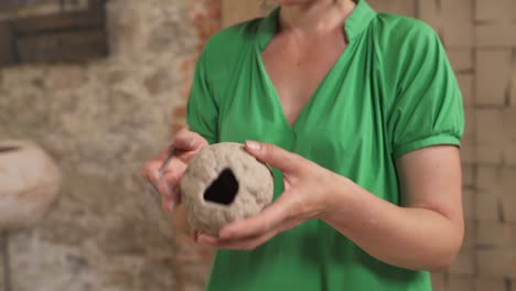 un primer plano de una escultora moldeando cerámica escultura de forma ovalada. arte moderno. concepto de pasatiempo y profesión