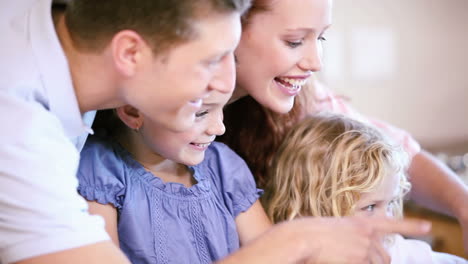 familia feliz mirando una computadora portátil
