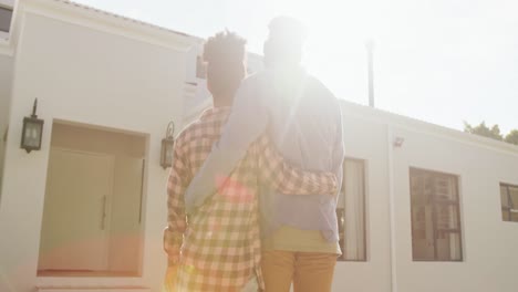 Video-of-back-view-of-african-american-couple-embracing-in-front-of-new-house