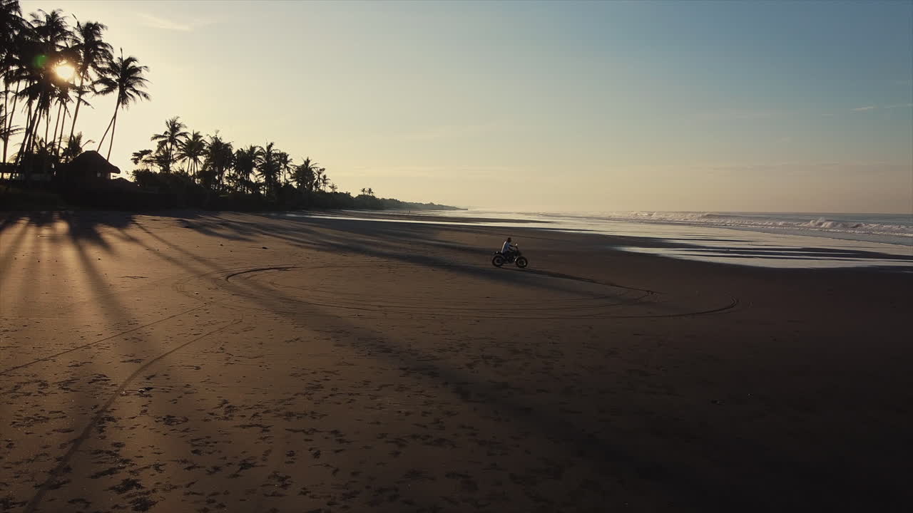 Giro in moto all'alba sulla spiaggia