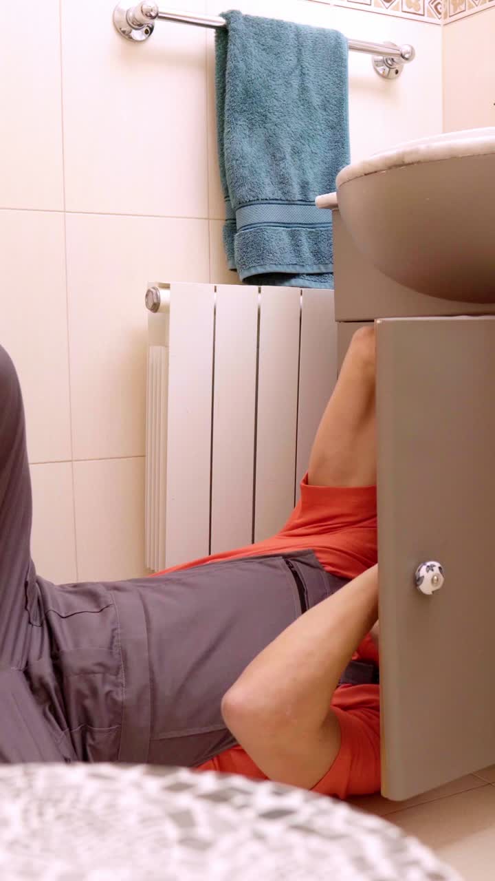 Plumber evaluating bathroom sink issue and explaining costs to customer