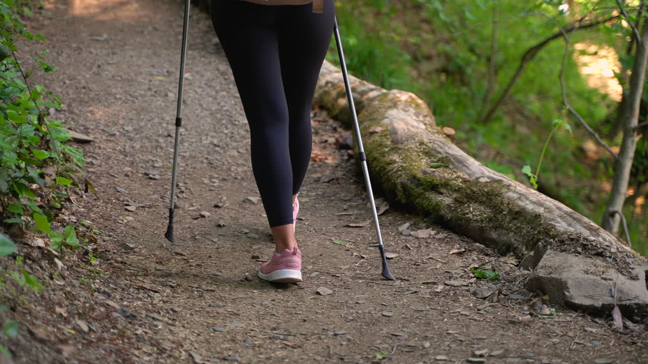 mujer caminando por el sendero del bosque