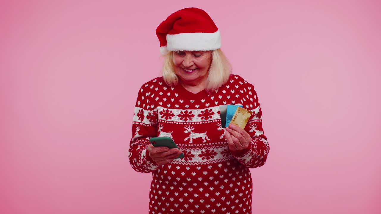 anciana de navidad abuela mujer usar teléfono celular plástico tarjetas bancarias de crédito ganar calebrate wow