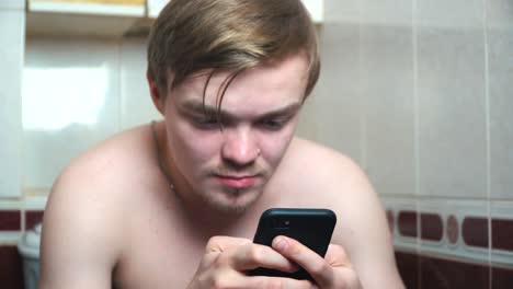 man using smartphone in a bathroom