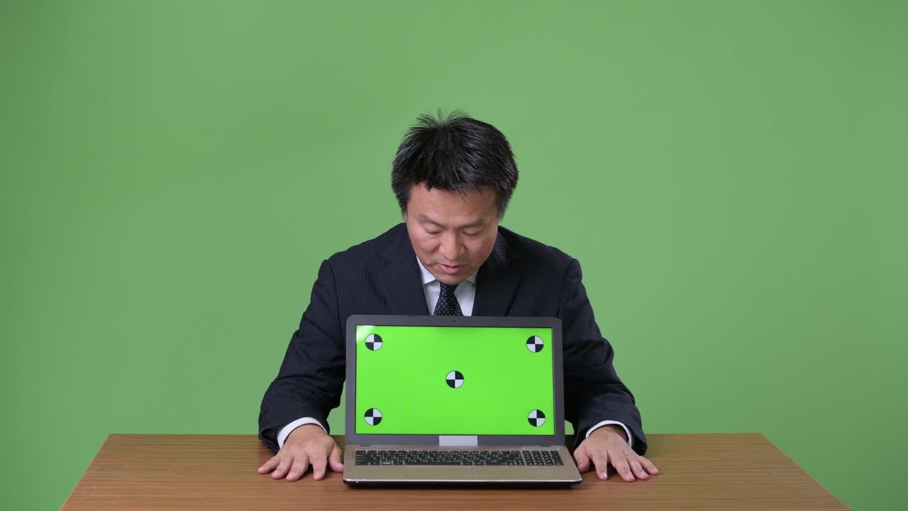 녹색 배경에 성숙한 일본 사업가