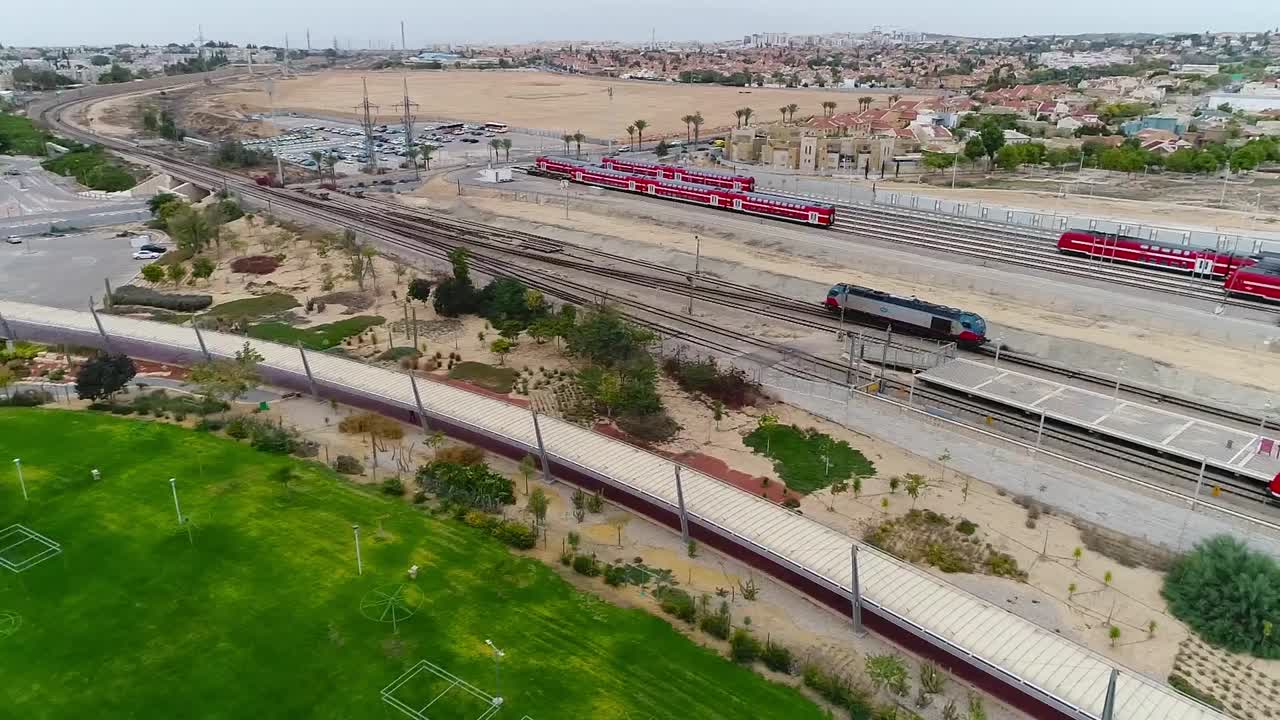 Aerial drone shot over a railway area and recreation spaces. On a sunny day.
