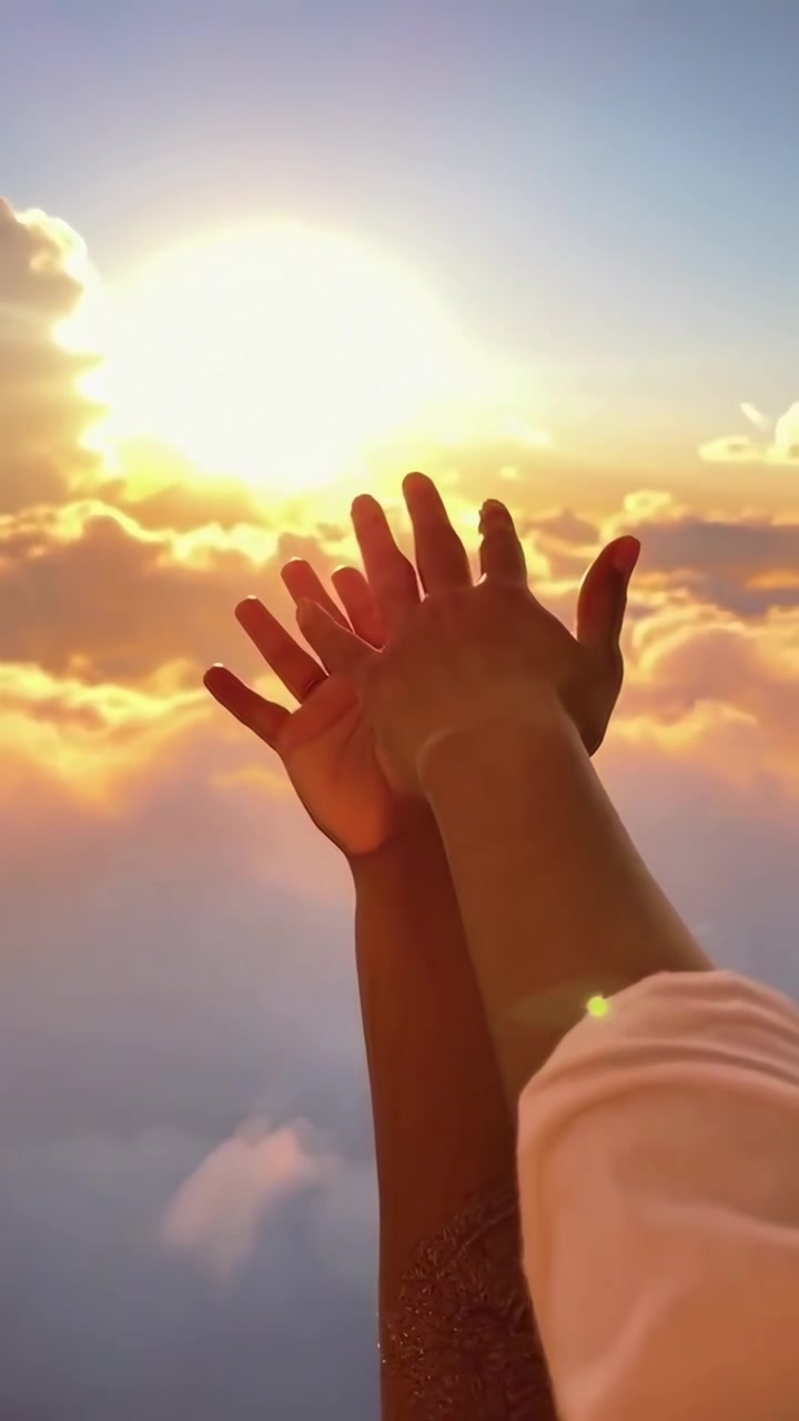 Due persone che tendono le mani verso il tramonto sopra le nuvole