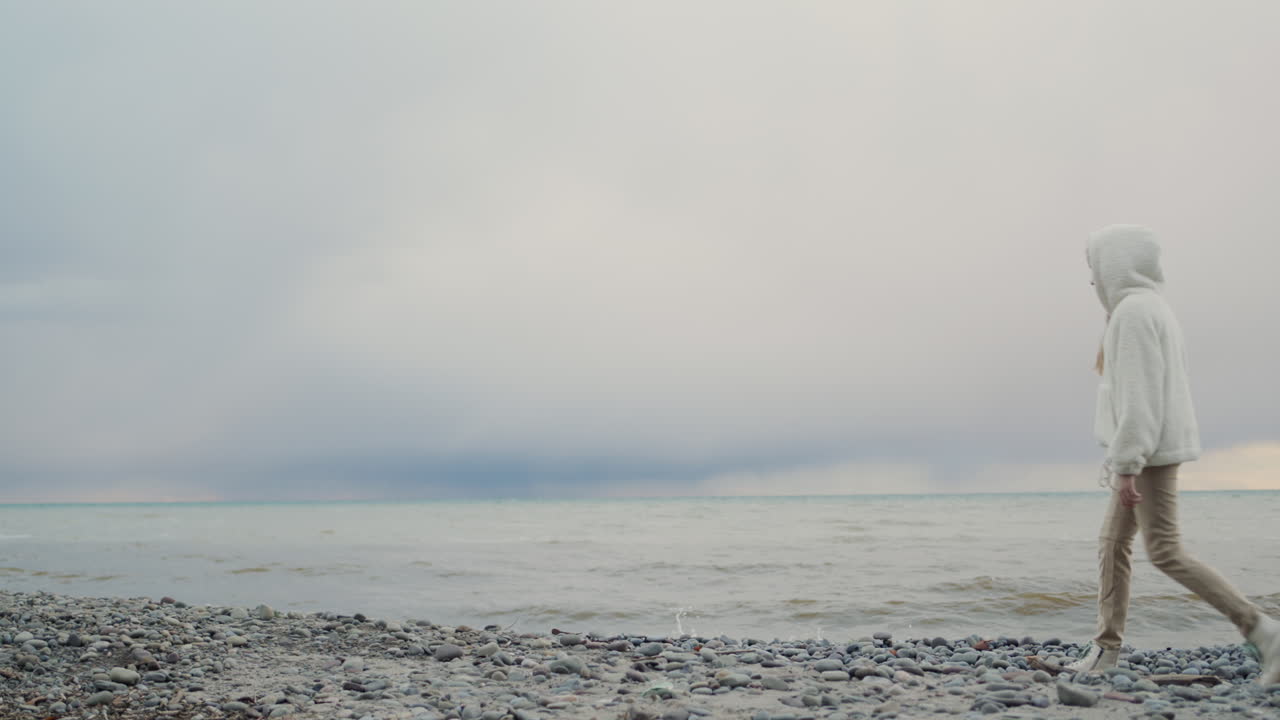 девочка-подросток гуляет по берегу живописного озера