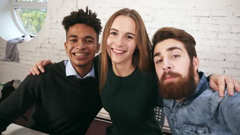 smiling casual business team posing while taking selfies in the office. creative diverse business team in modern office take