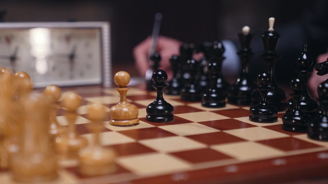 Mani che muovono i pezzi degli scacchi durante una partita strategica