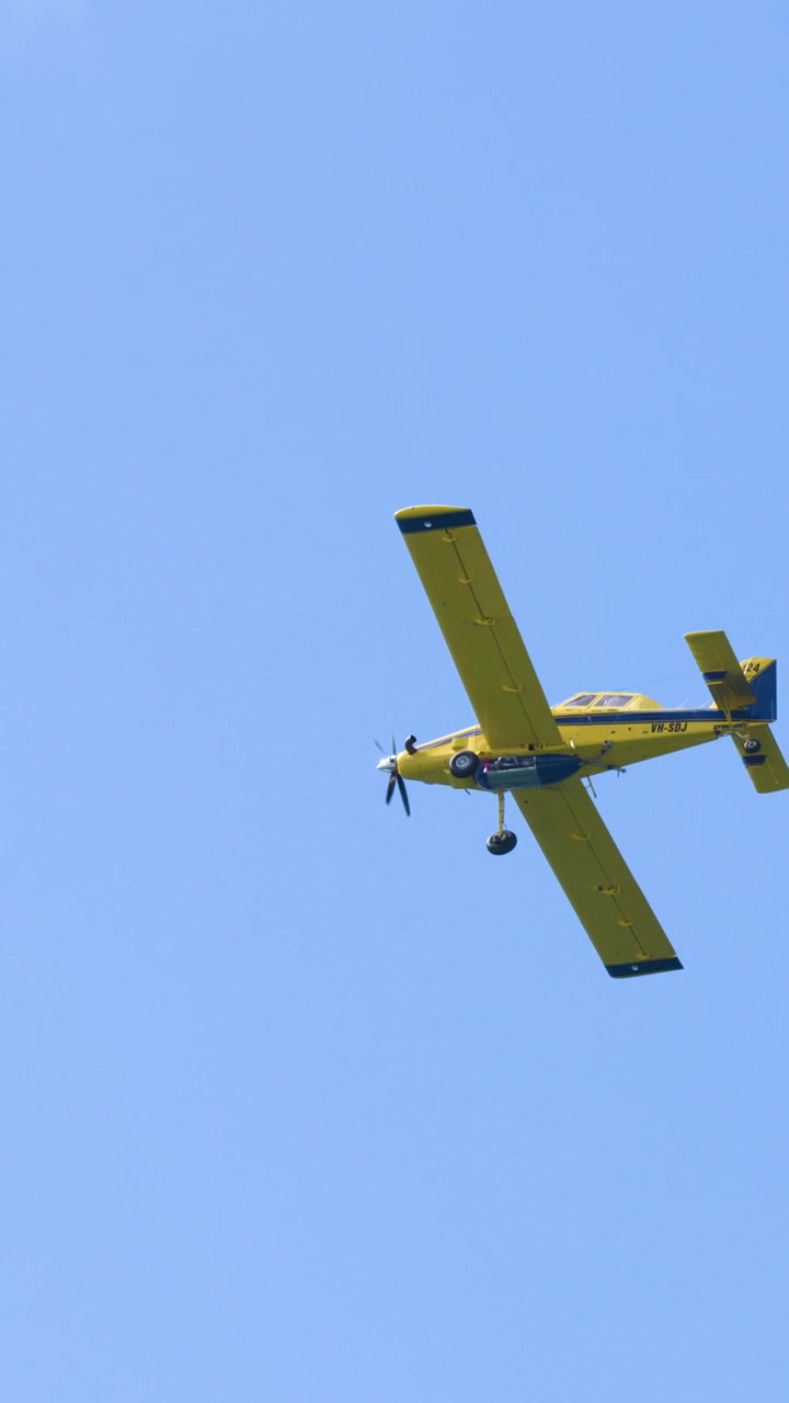 Un aereo a elica Air Tractor giallo sorvola un cielo azzurro brillante in Australia