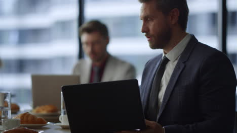 Gerente-Ocupado-Mostrando-Computadora-Portátil-A-Un-Colega-De-Negocios-En-La-Cafetería-Del-Restaurante.