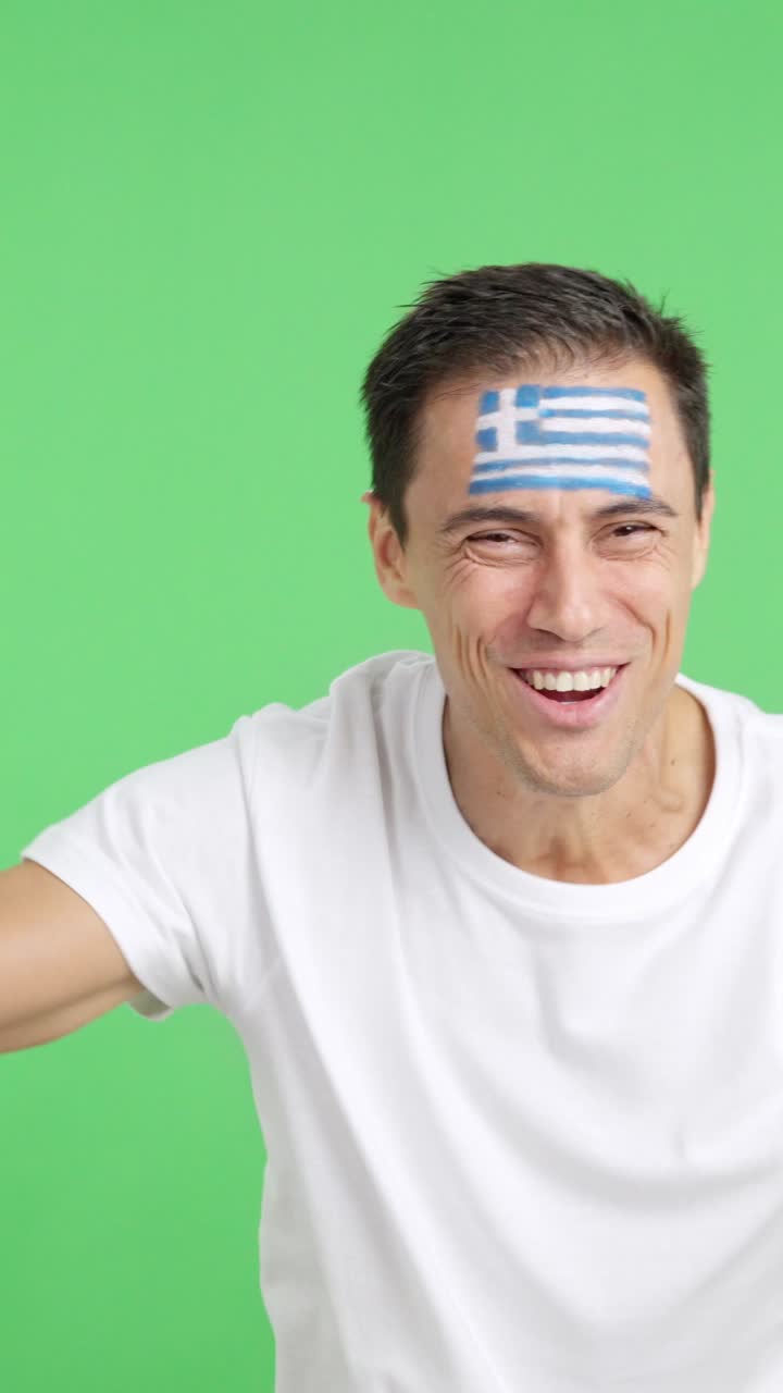 Man cheering for Greece screaming and waving a national flag