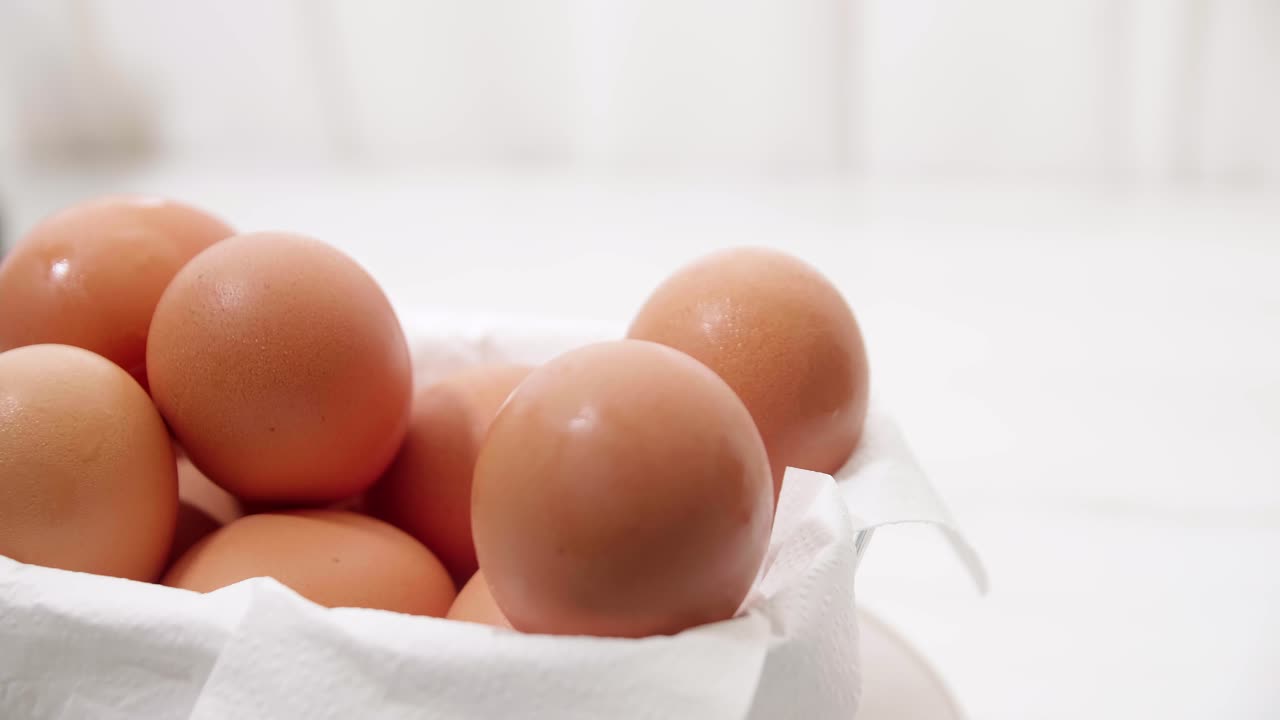 상자에서 갈색 계란을 꺼내는 남성 손을 닫습니다